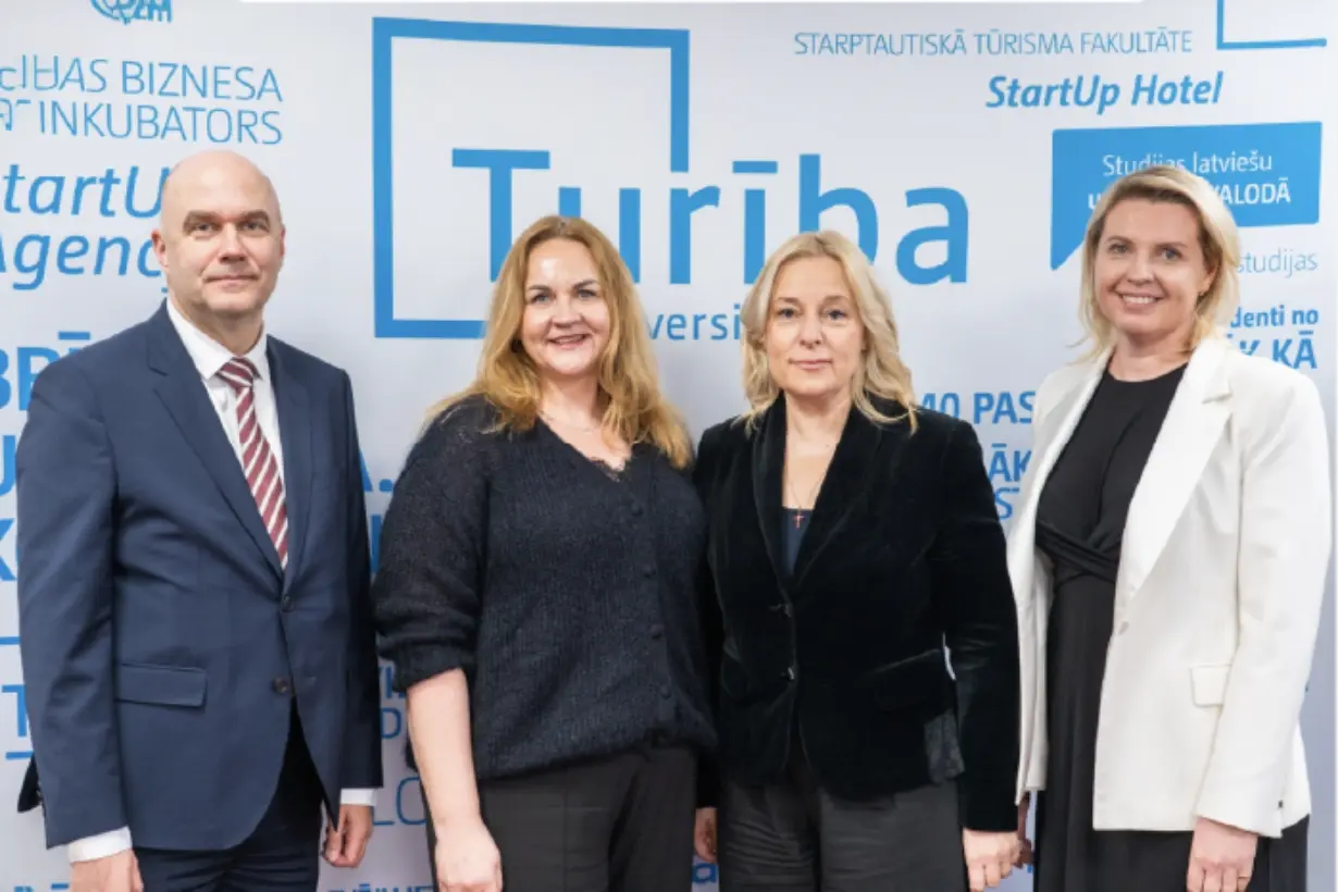 Turība universitātes baneris ar četriem cilvēkiem pie tā