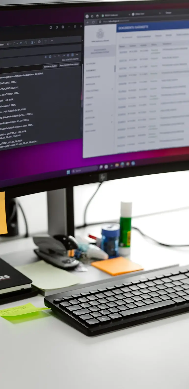 Dators uz galda ar atvērtām grāmatvedības sistēmām