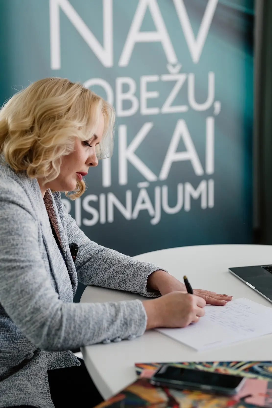 Kamelota darbiniece pieraksta grāmatvedības procesus uz baltas lapas