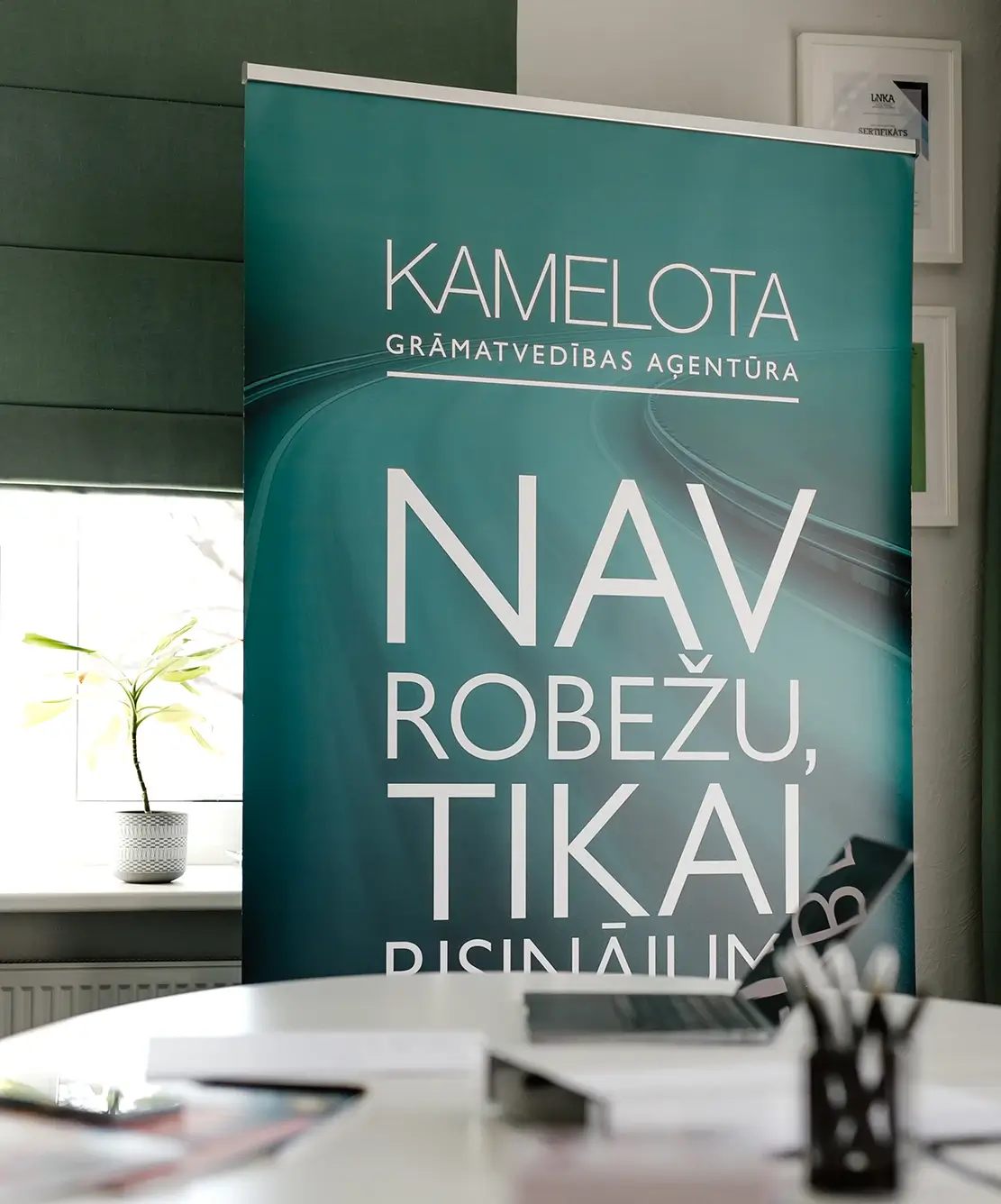 Baneris zaļā krāsā - Kamelota grāmatvedības aģentūra - Nav robežu, tikai risinājumi