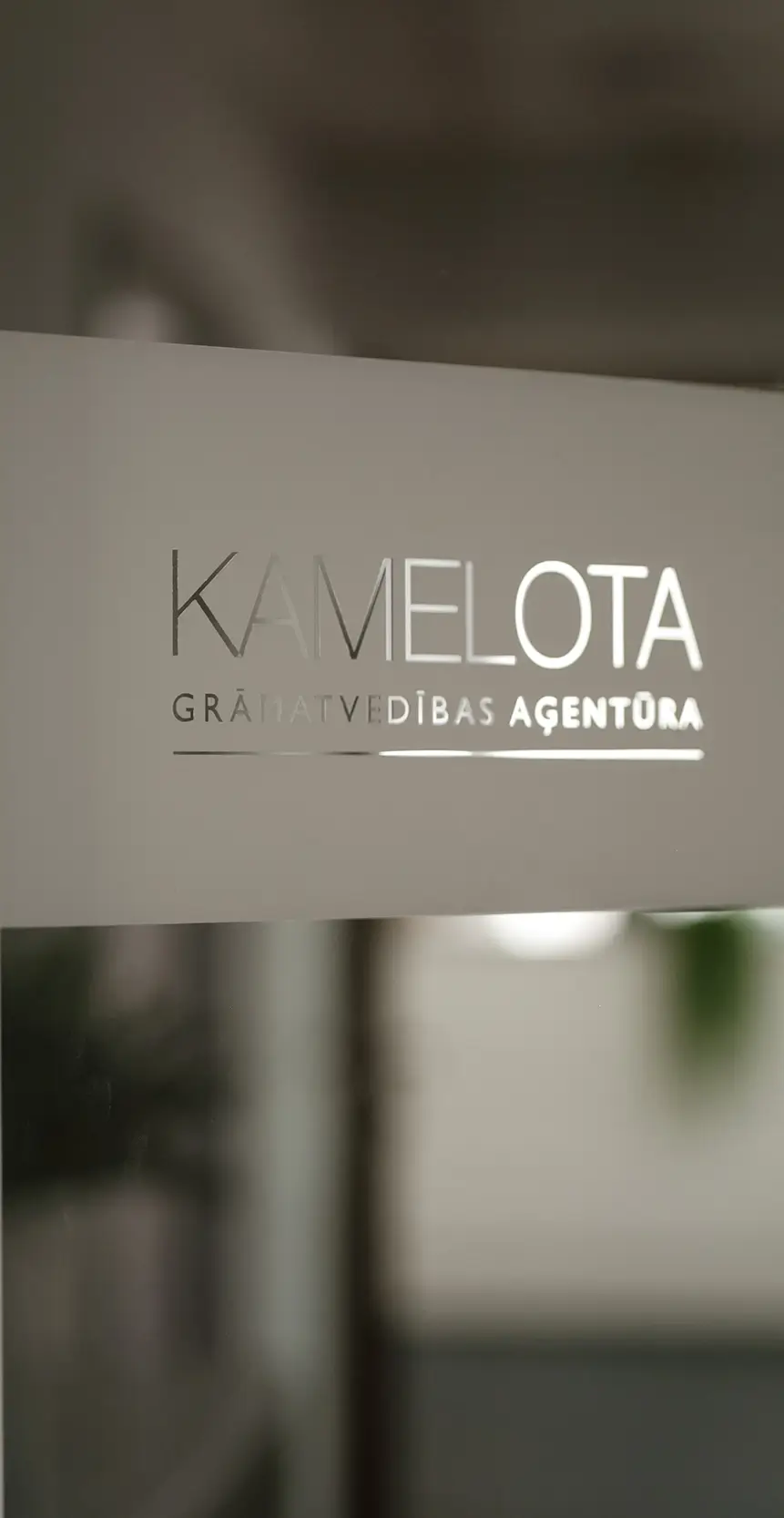 Kamelota Grāmatvedības aģentūra - uzraksts uz stikla durvīm
